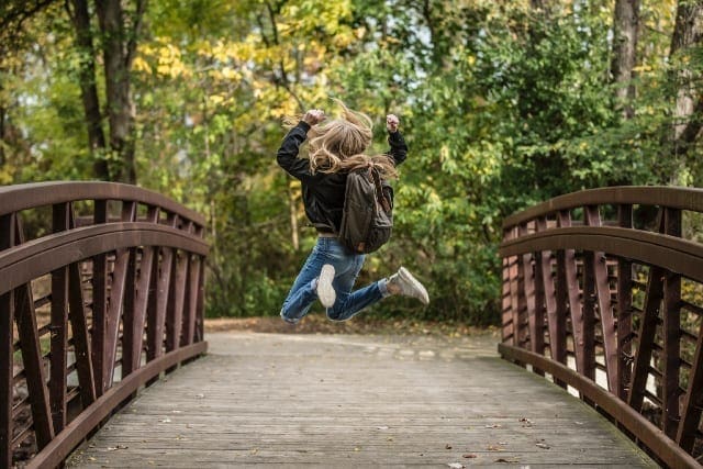 Character Strengths girl jumping on bridge|